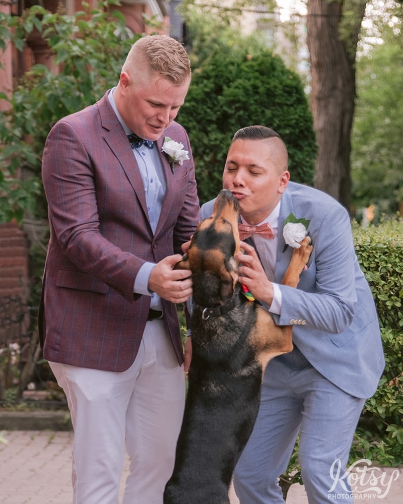 A dog jumps up on his two owners at their outdoor wedding ceremony at Berkeley Bicycle Club in Toronto