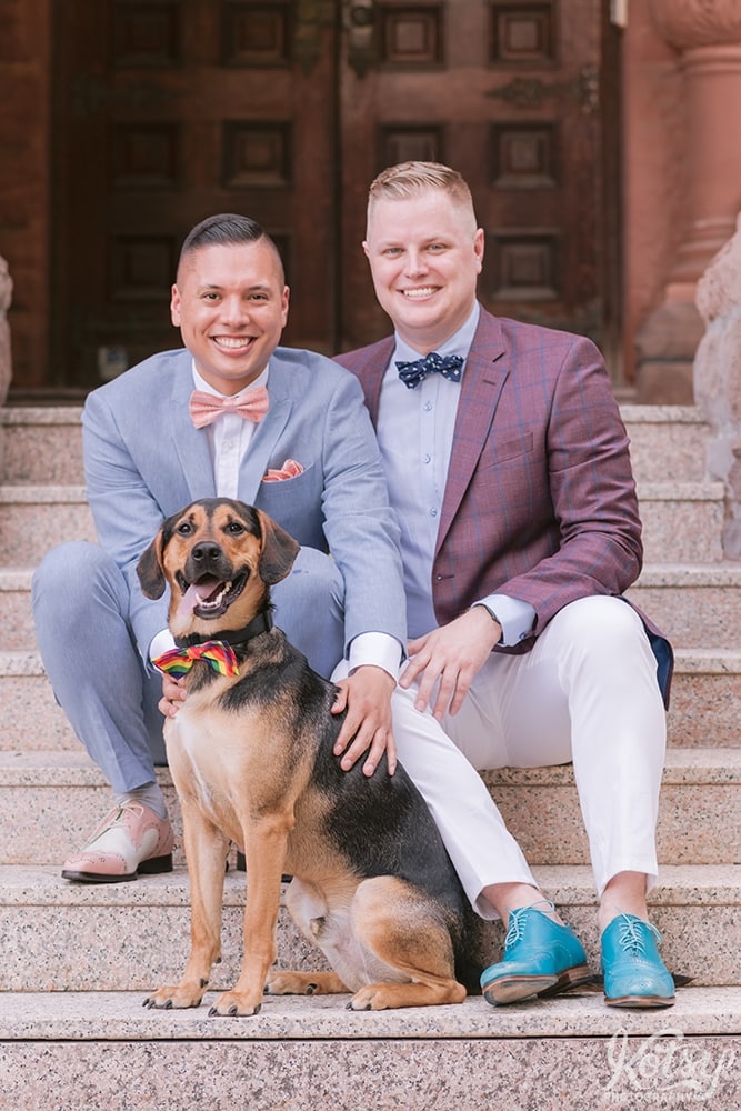 Two grooms sit with their dog on the stairs to the Berkeley Bicycle Club in Toronto, Ontario