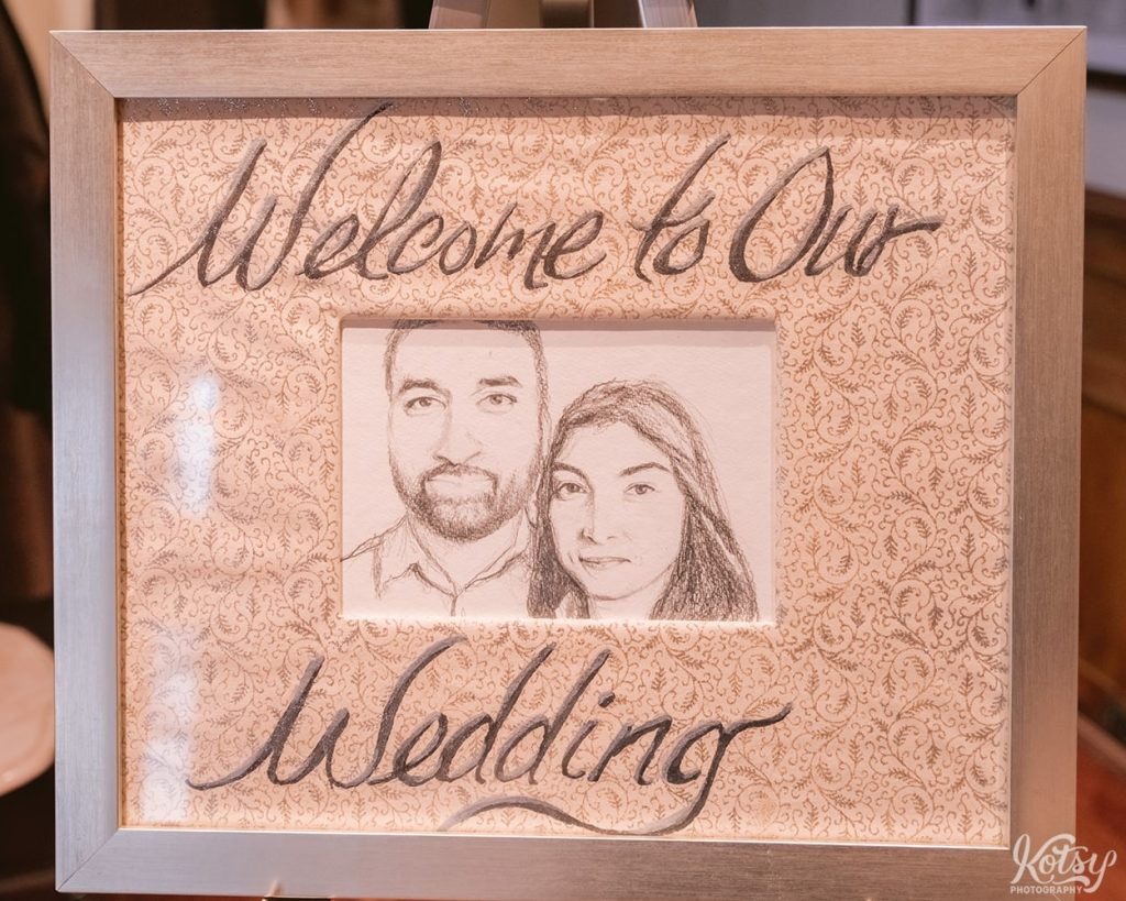 A welcome sign at a wedding ceremony with a pencil sketch of the couple.
