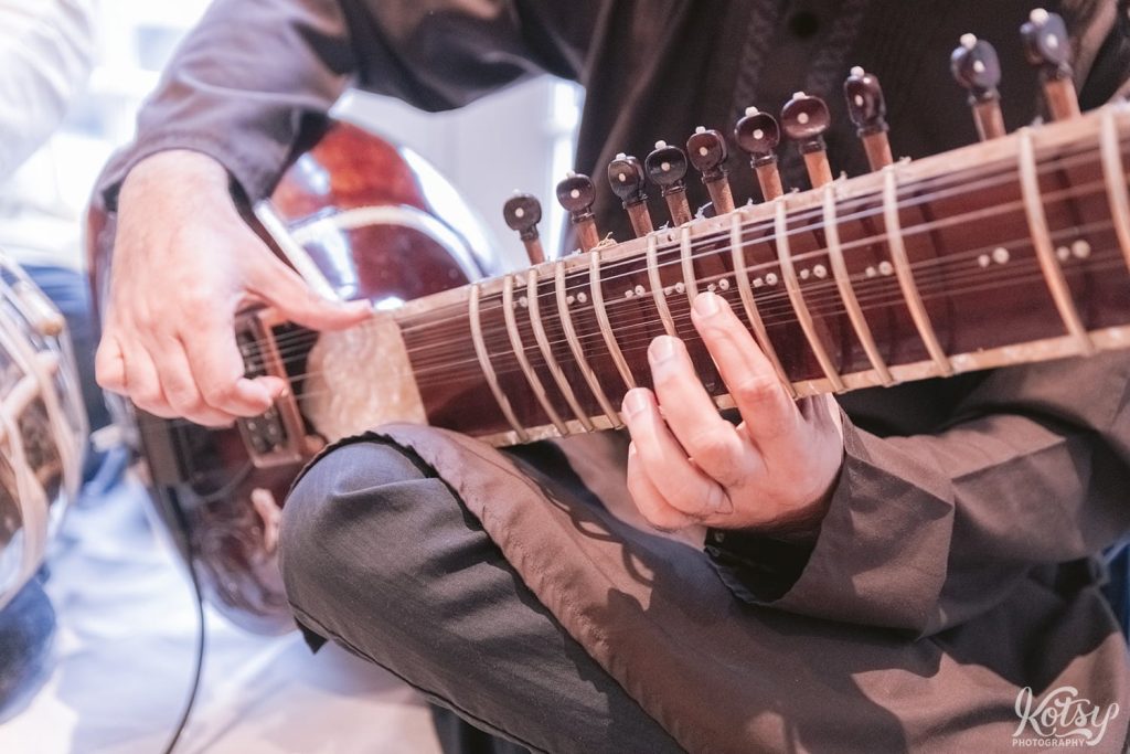 A close up shot of a sitar being played at a wedding reception at Guild Inn Estate.