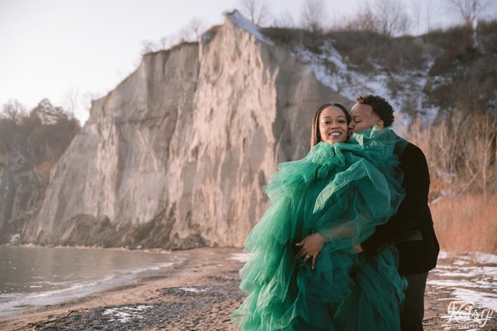 A man kisses his fiancé on the cheek at the Scarborough Bluffs in Toronto