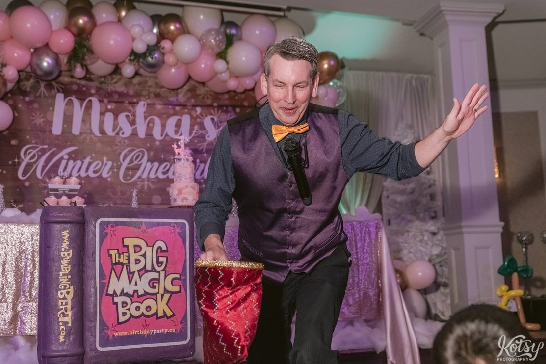 A magician performs in front of a crowd at a birthday party. Shot by a Toronto Event Photographer.