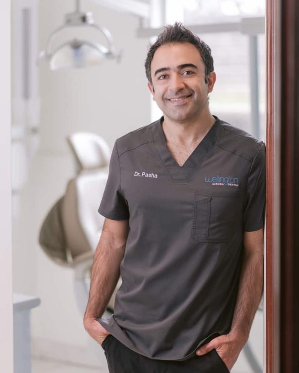 A dentist poses for a portrait in his dental office