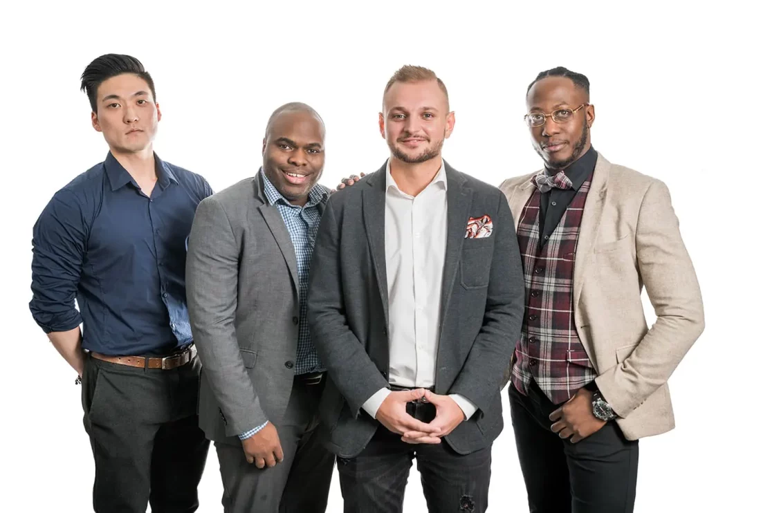 A group of men dressed up pose for a photo in front of a white background