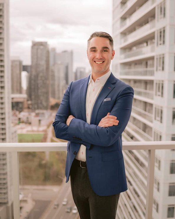 A man poses for a portrait on a high rise condo balcony in Toronto