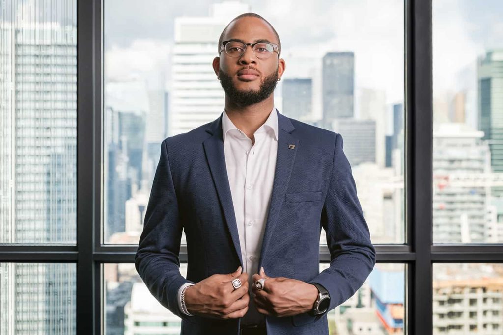 A man poses in a blue suit in a high-rise condo in Toronto
