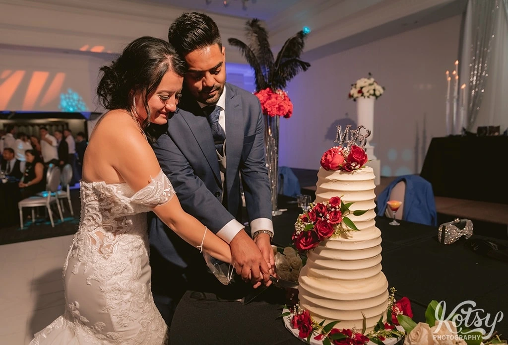 A bride and groom cut their wedding cake during their wedding reception at The Venu Event Space in Woodbridge, Canada