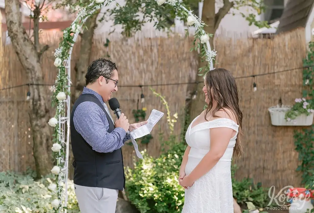 A groom reads wedding vows to his bride during a backyard wedding in Toronto, Canada