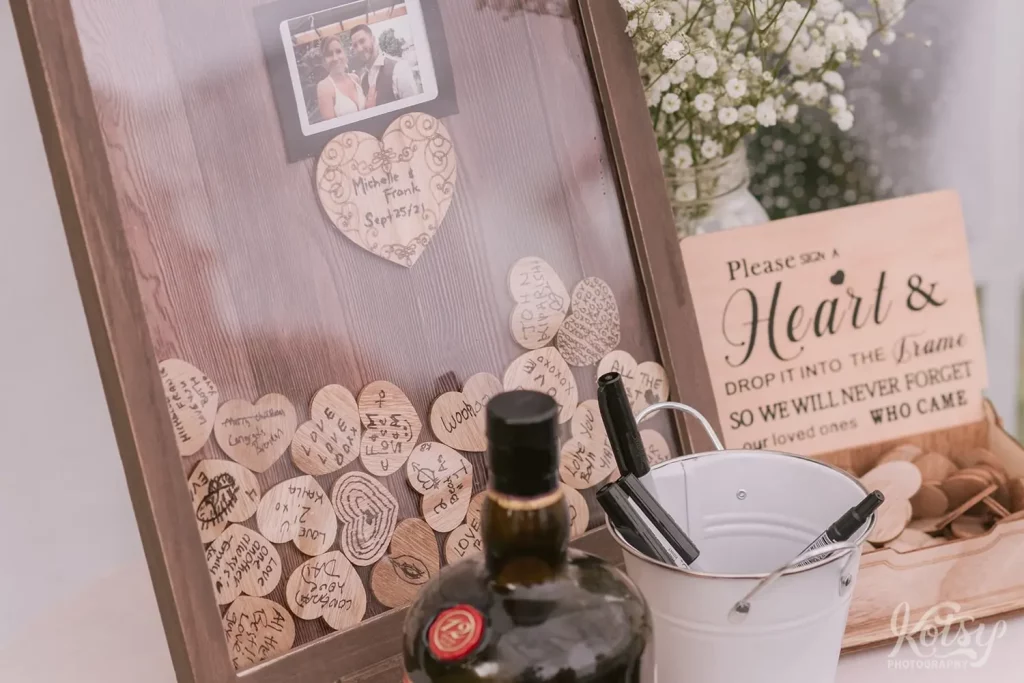 Little signed hearts are seen in a picture frame with a polaroid picture of the bride & groom in the middle.