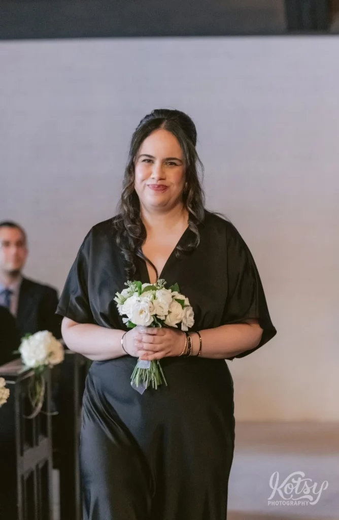 A second bridesmaid makes her way down the aisle at the Old Mill chapel in Toronto