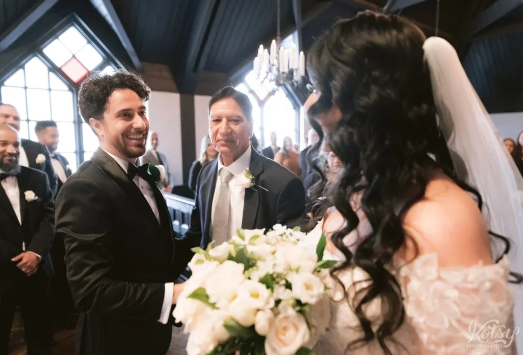 A groom greets his bride on her arrival to the alter at their Old Mill wedding in Toronto