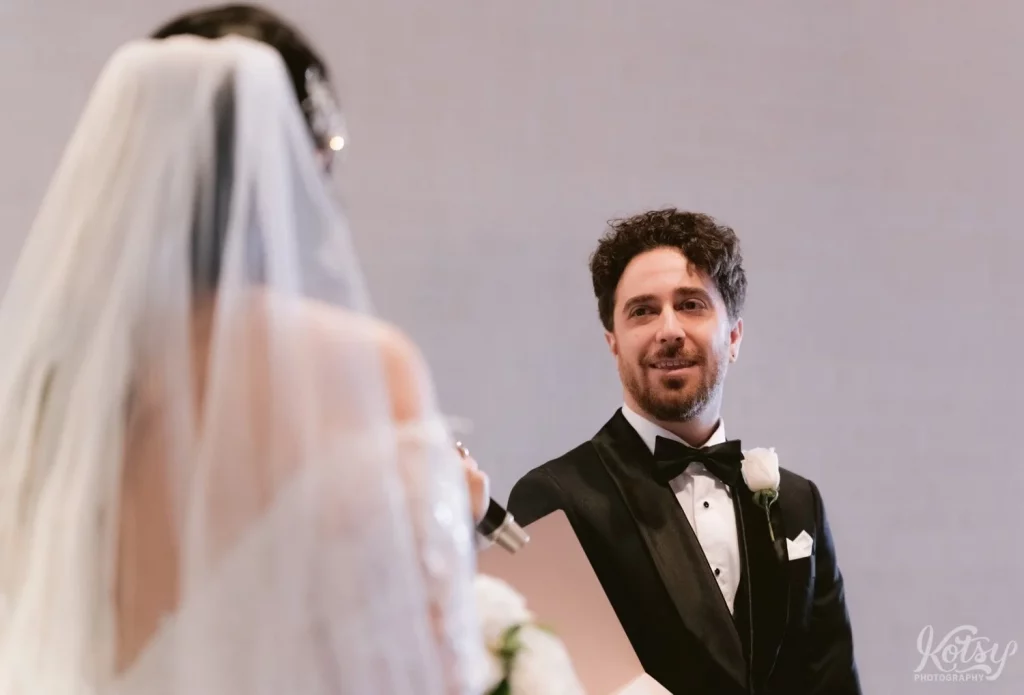 A groom with a heavenly smile gazes at his bride at Old Mill in Toronto