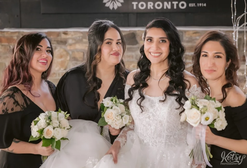A bride smiles for the camera with her bridesmaids at Old Mill in Toronto.