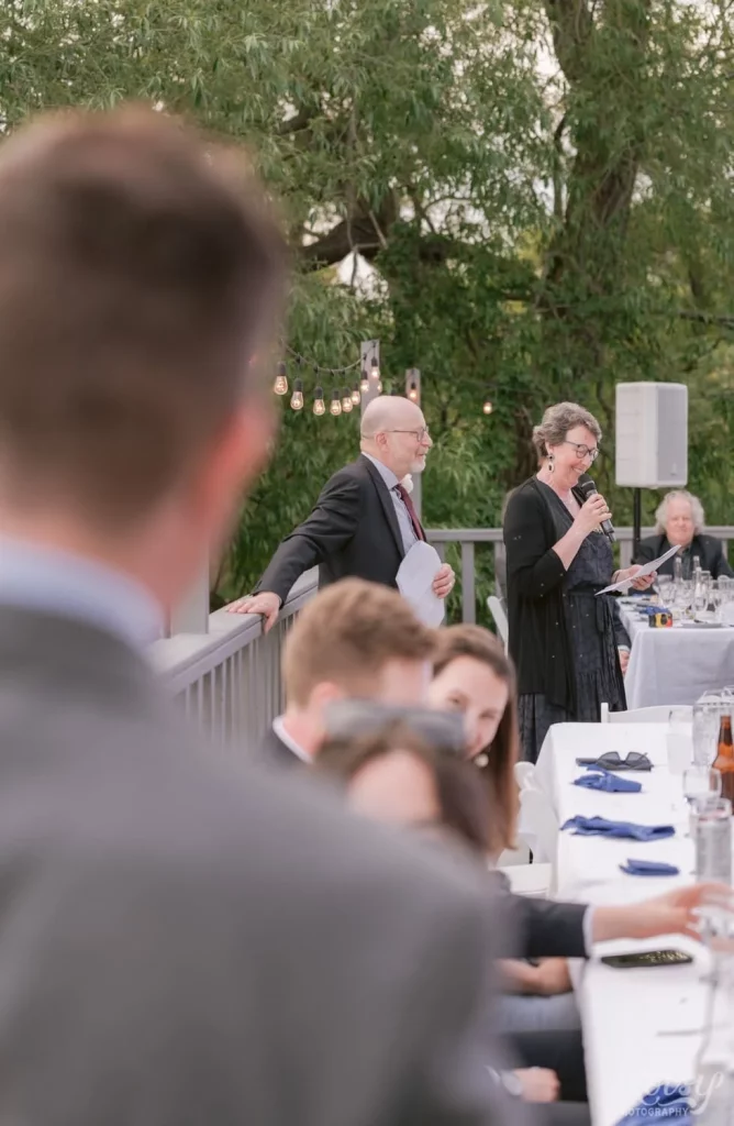 A bride's mother does her speech during an outdoor wedding ceremony