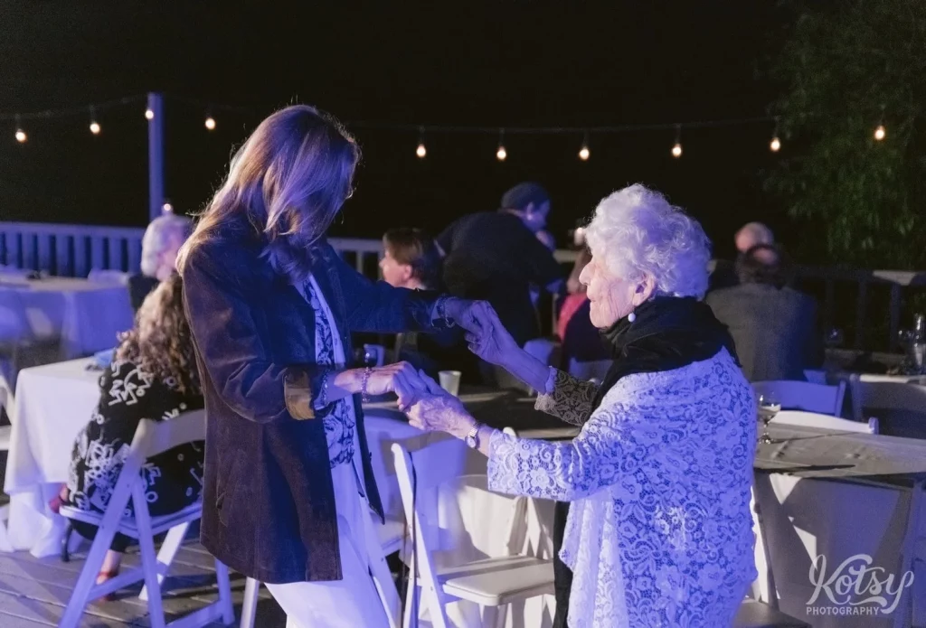A woman dances with an elderly woman at an outdoor wedding reception in Toronto