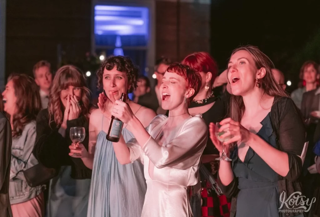 Women cheer during a band's performance at an outdoor wedding reception in Toronto