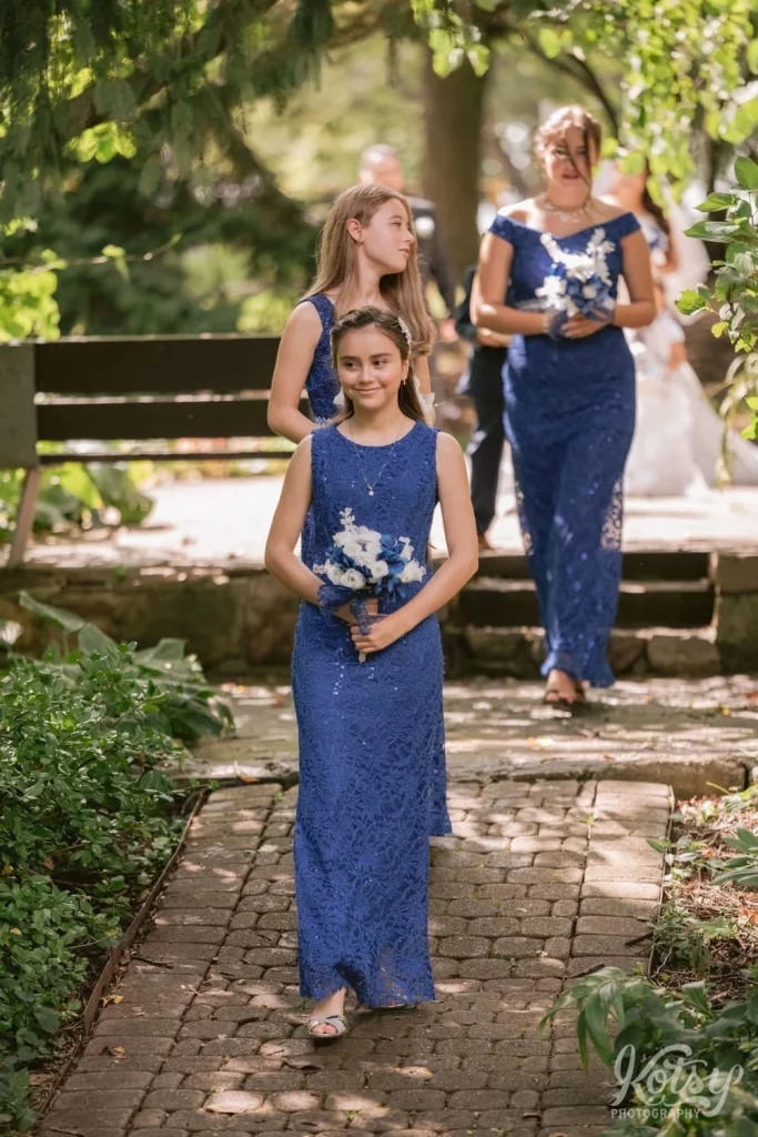 A bridesmaid makes her way down the aisle during an outdoor wedding ceremony