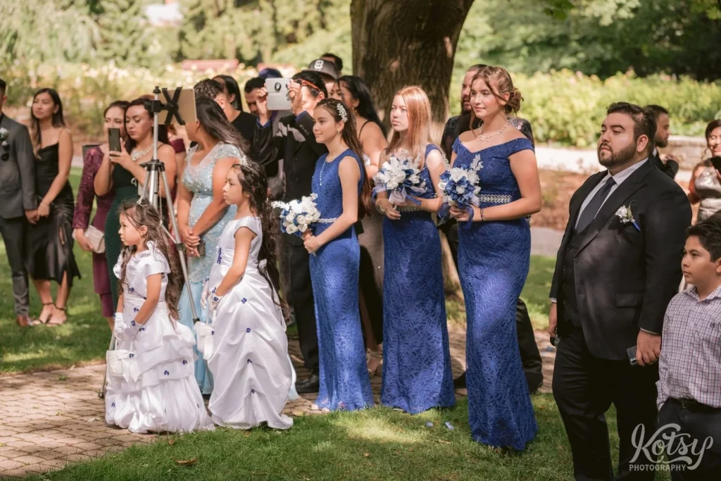 A group of guests watch an wedding ceremony off camera happening off camera