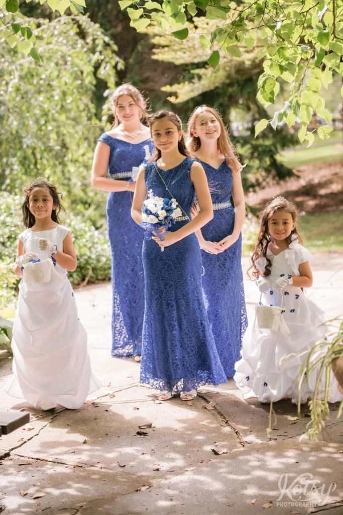 Bridesmaids and flower girls pose for a group photo before a wedding ceremony at Rosetta McClain Gardens