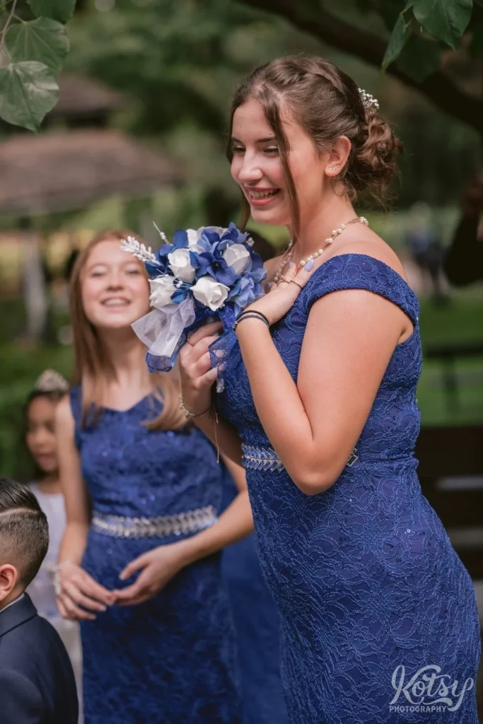 A bridesmaid in a blue dress enjoys a laugh