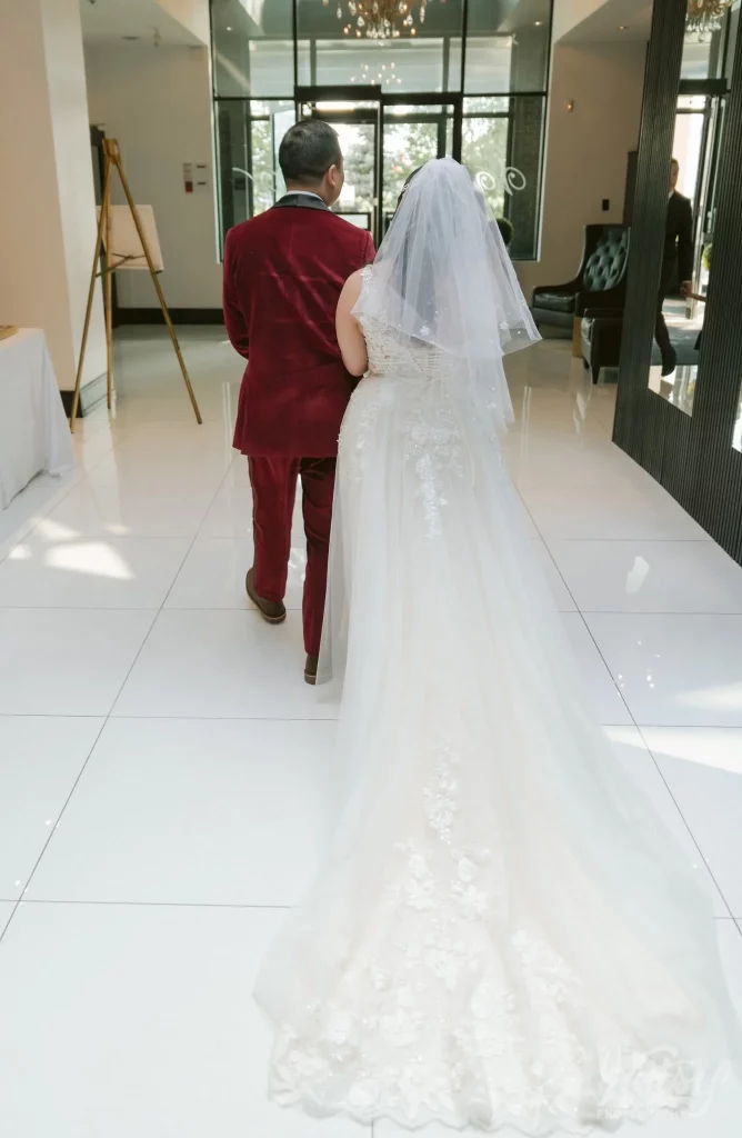 A bride's long train is seen as they exit the ceremony hall at The Vue Event Venue in Toronto