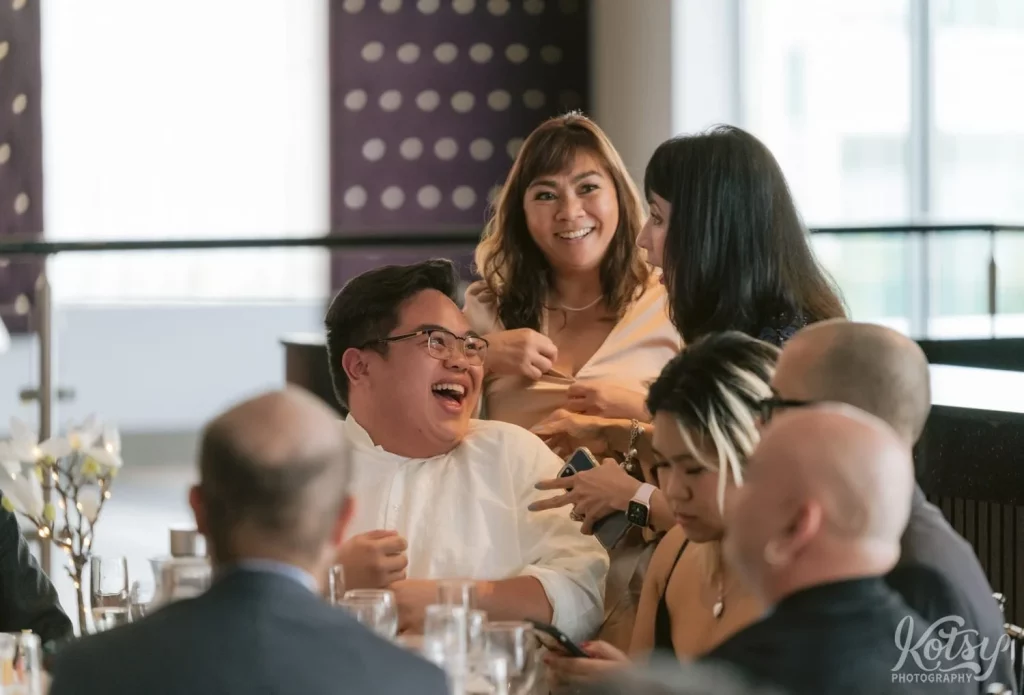 A man enjoys a laugh while talking to a woman during a wedding at The Vue Event Venue in Toronto