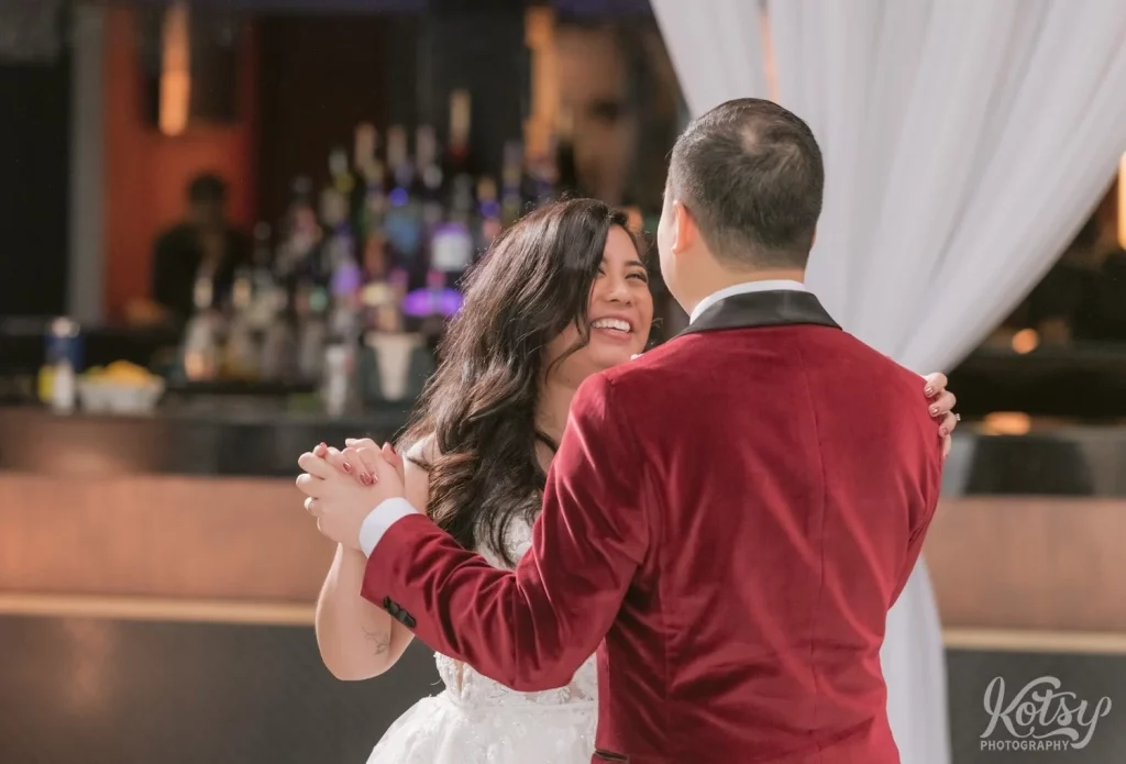 A bride smiles at her groom as they enjoy their first dance at a wedding in The Vue Event Venue in Toronto