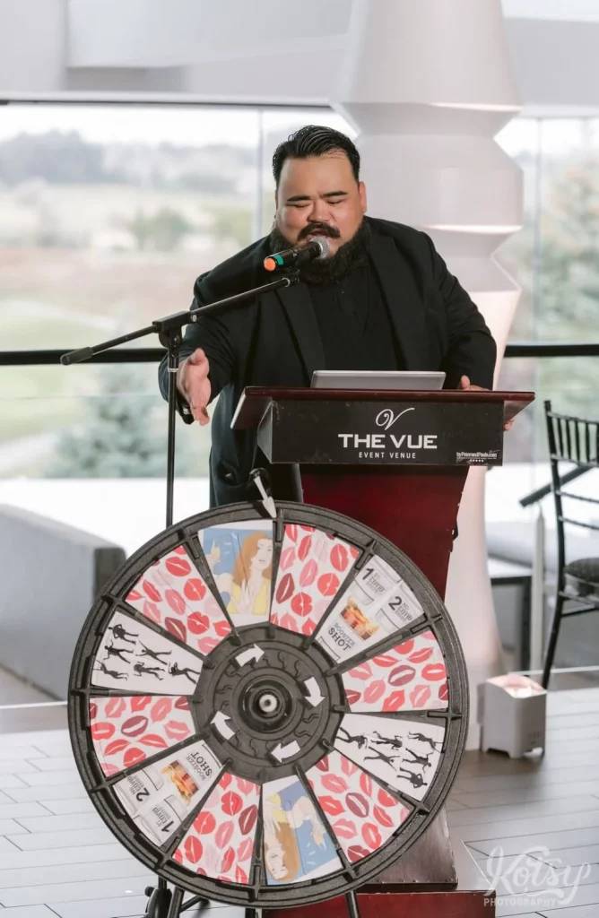 An MC introducers his Kissing Wheel during a wedding at The Vue Event Venue in Toronto
