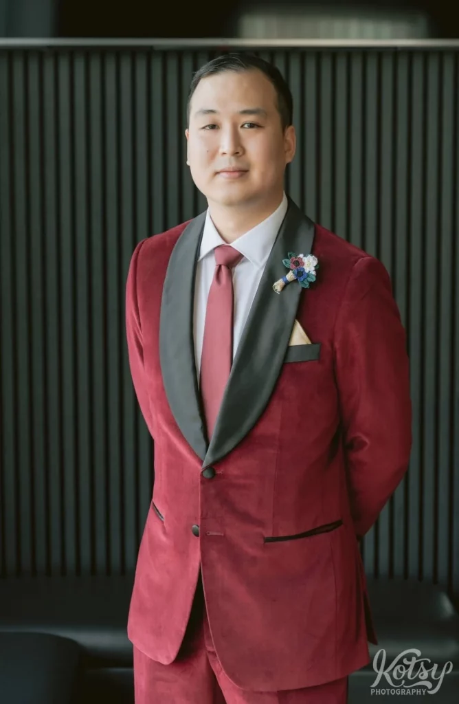 A groom in a burgandy suit at The Vue Event Venue
