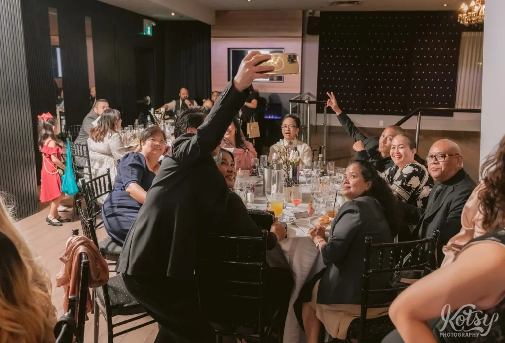 A man poses for a selfie with a table at a wedding reception. Photographed at The Vue Event Venue in Toronto