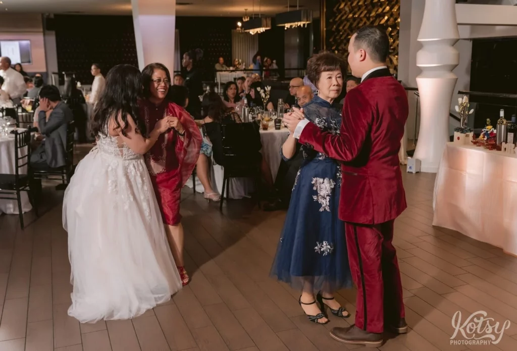 A bride and groom enjoy a dance with their mothers during a wedding reception at The Vue Event Venue in Toronto