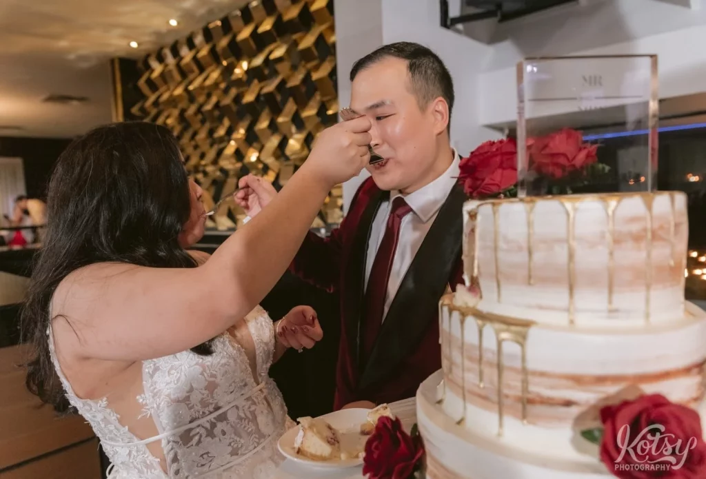 A bride and groom feed each other cake at their wedding reception in The Vue Event venue in Toronto