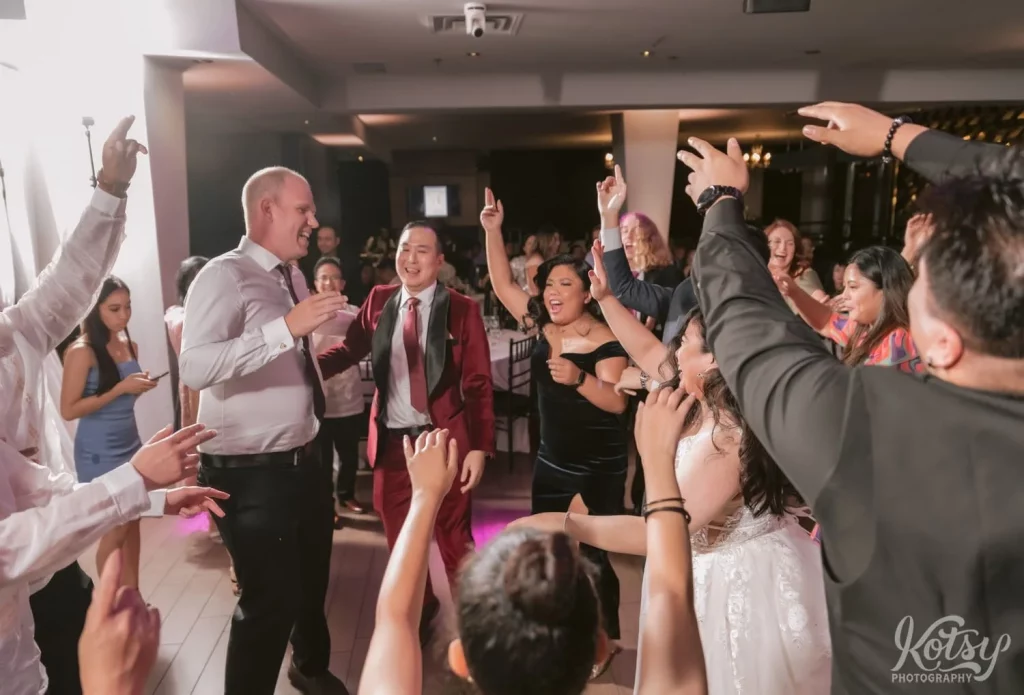 Everybody puts their hands up on a dancefloor at a wedding at The Vue in Toronto