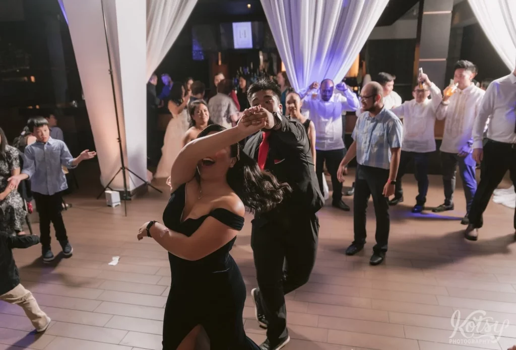 A man spins a woman while dancing at a wedding reception at The Vue Event Venue in Toronto