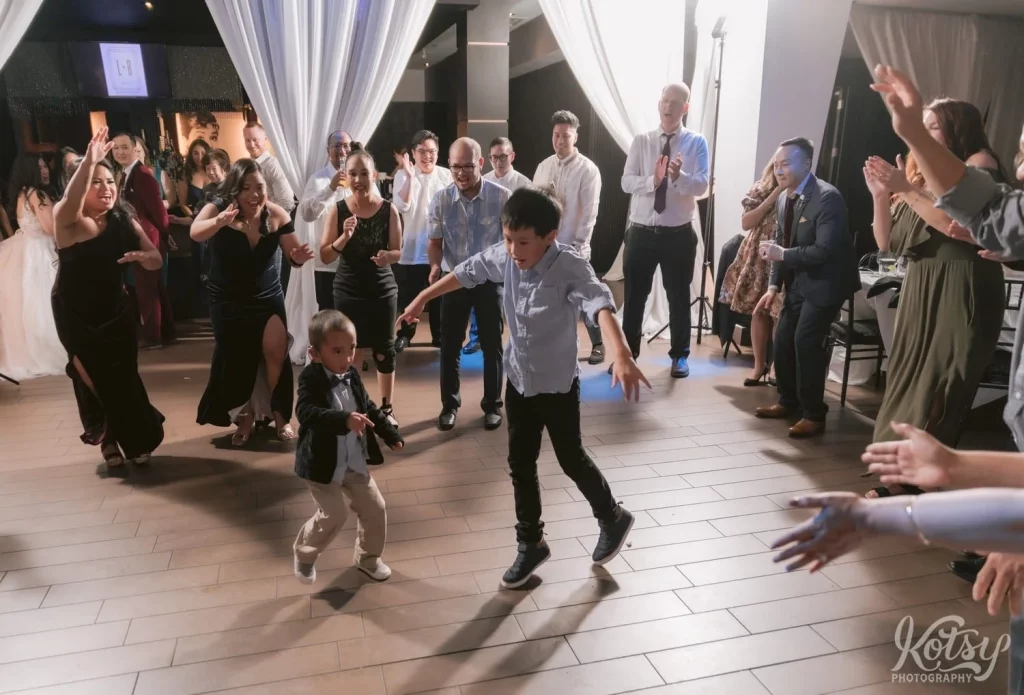 Two kids dance in the middle of a circle at a wedding reception in Toronto