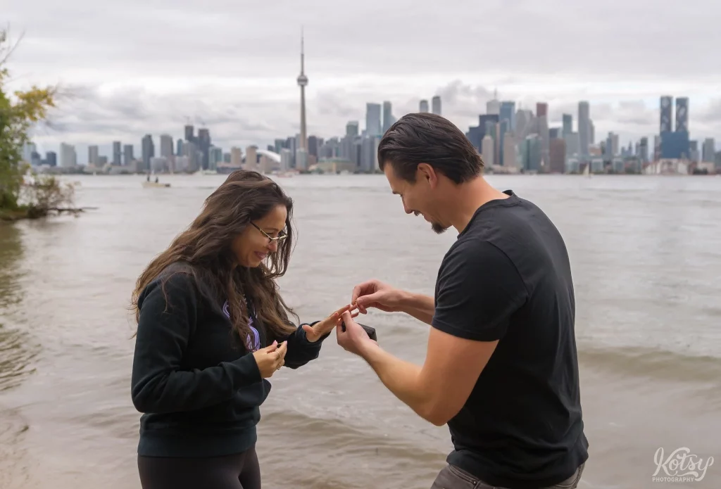 A man puts an engagement ring on his new fiance's finger at Toronto Islands