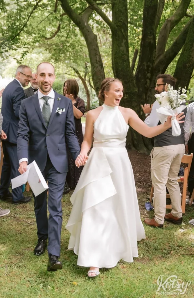 A bride and groom make their way back up the aisle during their Edwards Gardens wedding in Toronto