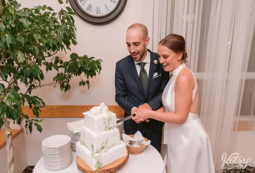 A bride and groom cut their cake at their wedding reception at The Prague Restaurant in Scarborough
