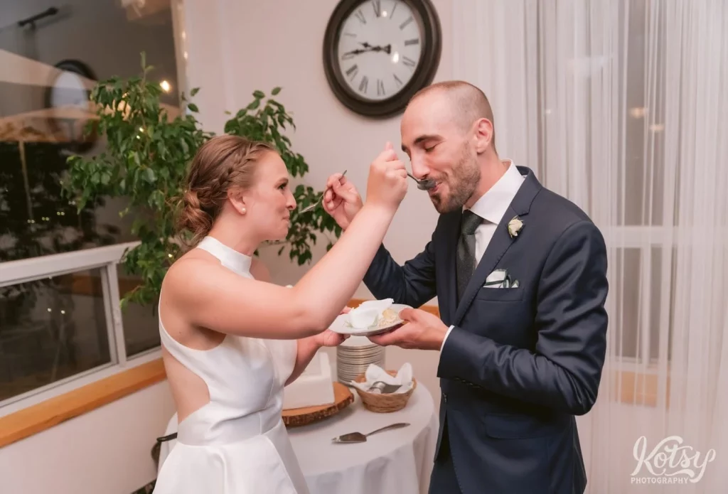 A bride and groom feed each other cake at their wedding reception at The Prague Restaurant in Scarborough