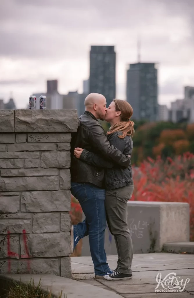 A couple kiss at Governor's Bridge Lookout at Don Valley Brick Works Park in Toronto