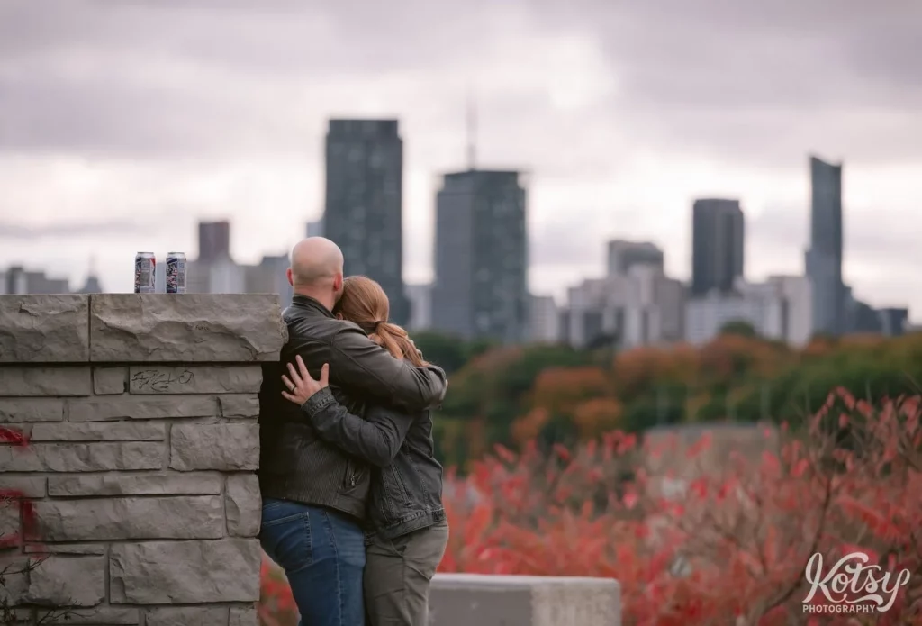 A man hugs his fiance at Governor's Bridge Lookout at Don Valley Brick Works Park in Toronto