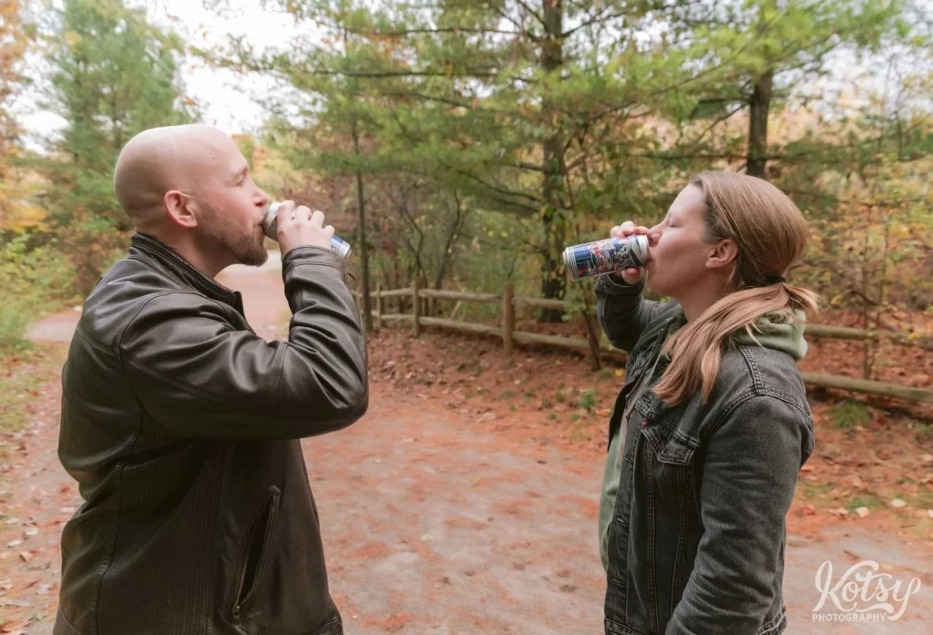 An engaged couple sip beers on a trail in Don Valley Brick Works Park