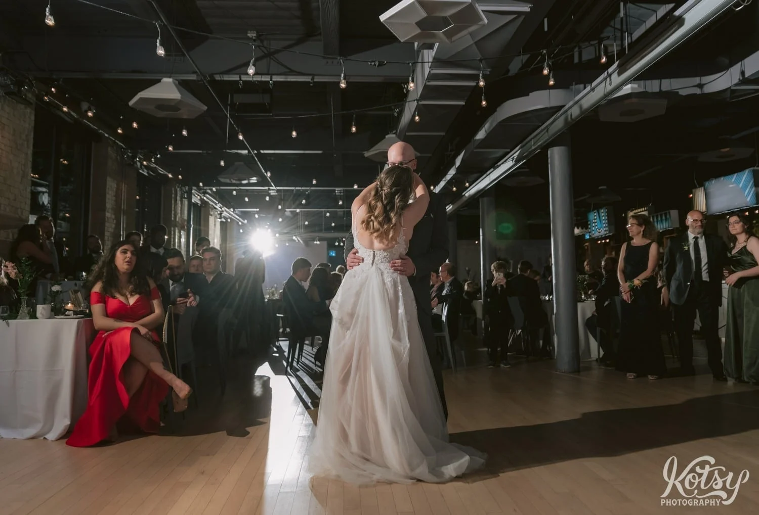A wide shot from behind a bride and a white wedding gown dancing with her groom during their Second Floor Events wedding reception in Toronto, Canada.
