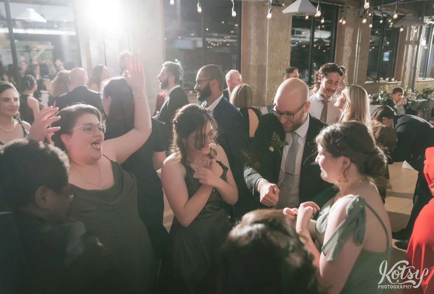A crowd of people dance excitedly at a Second Floor Events wedding reception in Toronto, Canada.