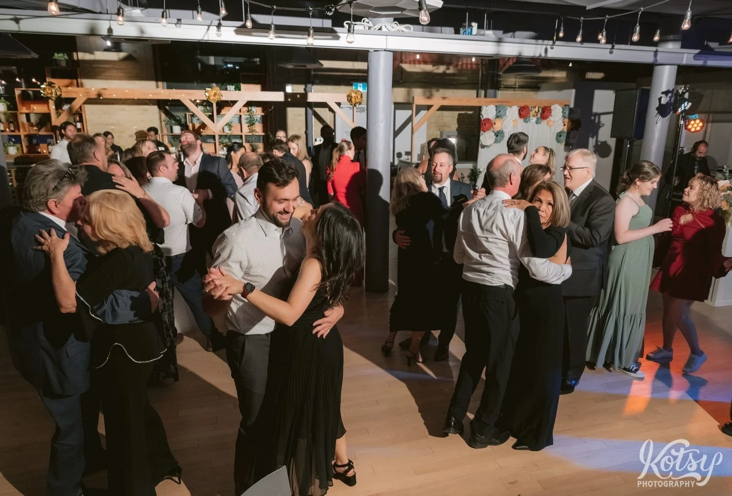 A wide shot of a group of people in formal attire dancing during a Second Floor Events wedding reception in Toronto, Canada.