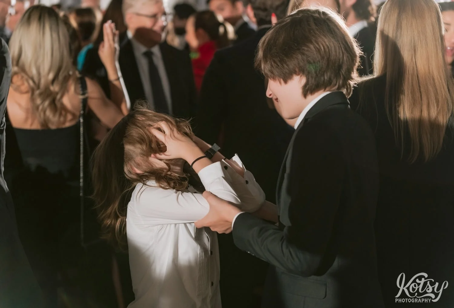 A kid is seen with his hair and hands covering his face during a Second Floor Events wedding reception in Toronto, Canada.