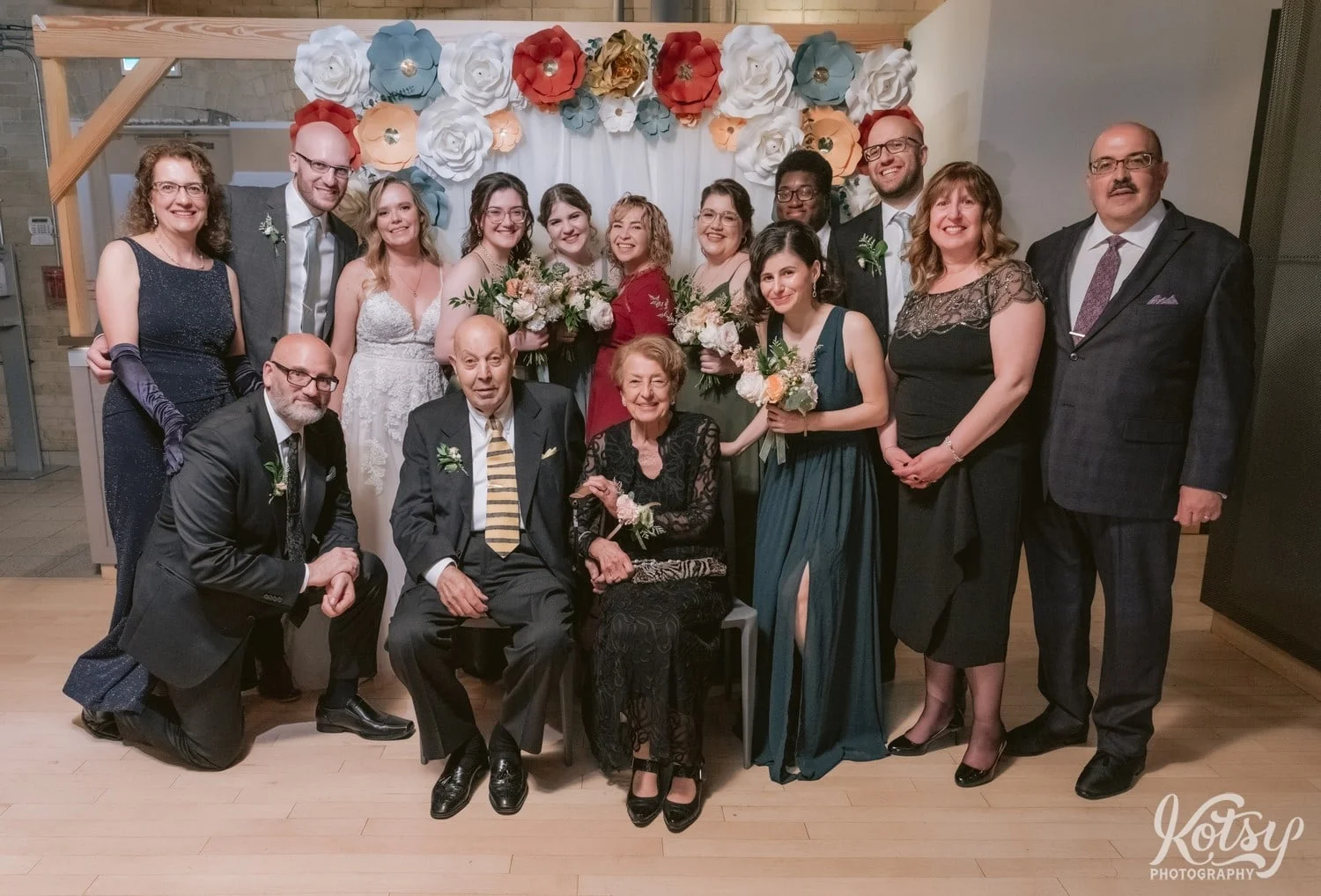 A family group shot in front of a backdrop during a Second Floor Events wedding reception in Toronto, Canada.