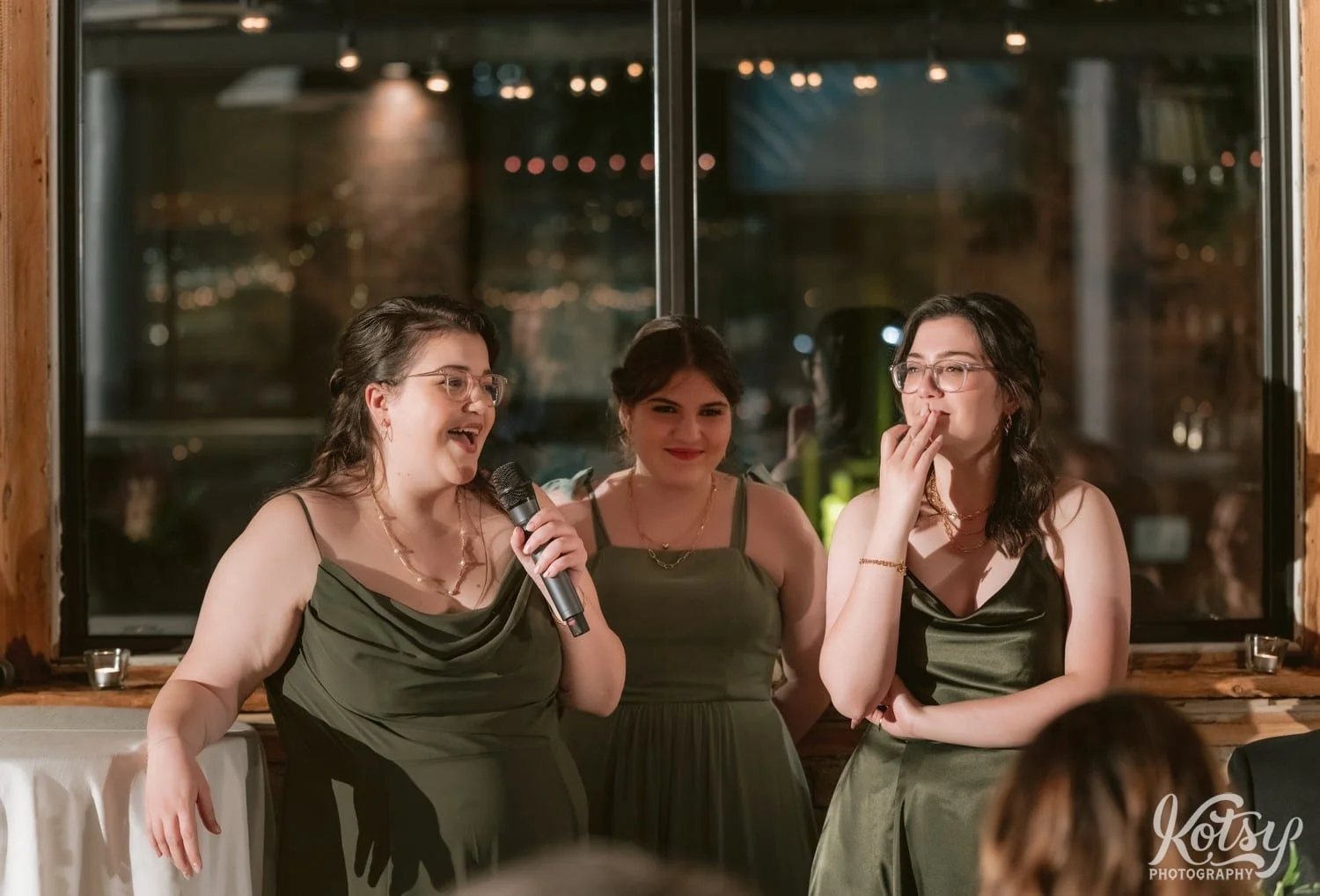 Three women in green dresses make a speech during a Second Floor Events wedding reception in Toronto, Canada.