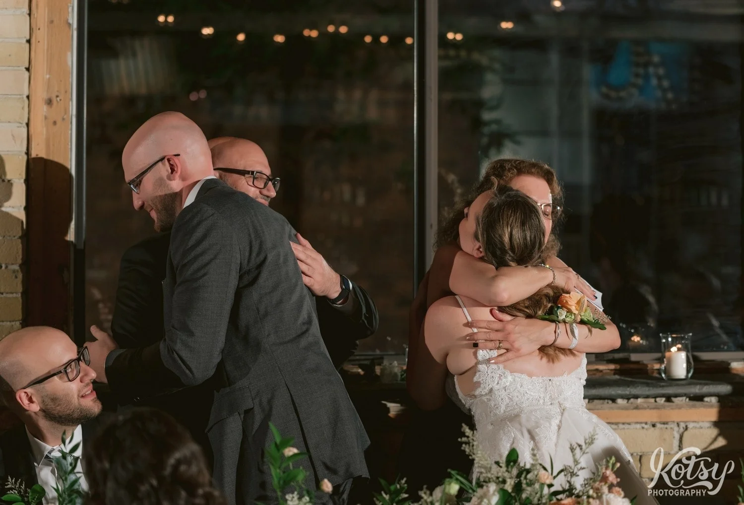 A bride and groom enjoy a hug from the groom's parents during Second Floor Events wedding reception in Toronto, Canada.