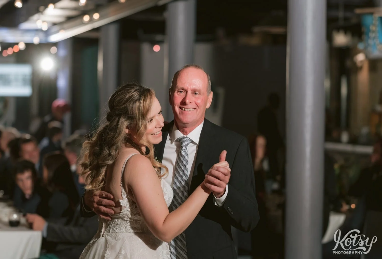 A man in a black suit smiles at the camera as he dances with his daughter in a white wedding gown during Second Floor Events wedding reception in Toronto, Canada.